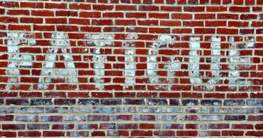 The word "FATIGUE" painted onto a brick wall