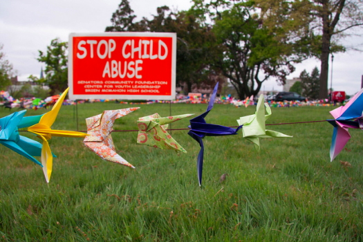 Garland of paper cranes in field depicting child abuse awareness
