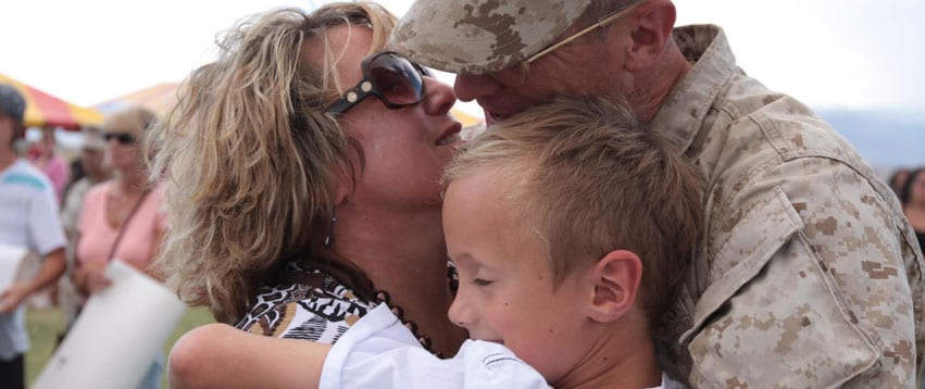 Military family hugging with child