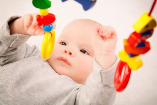 baby reaching and grabbing toy