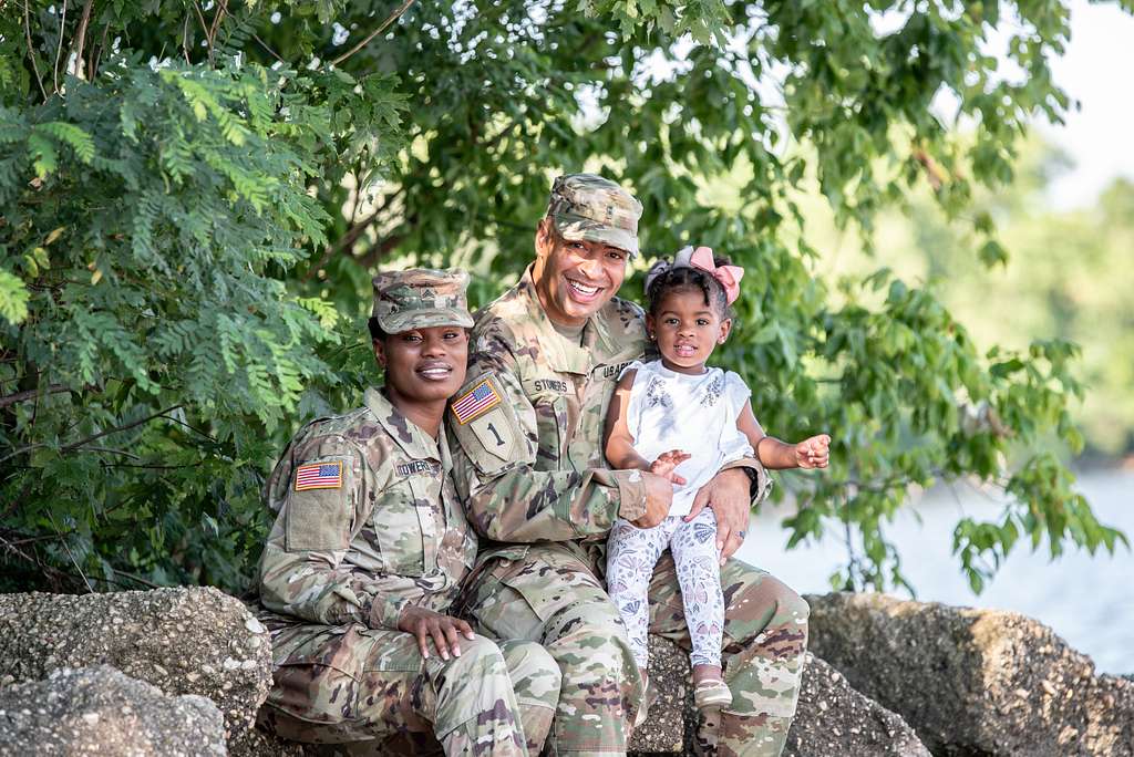 smiling dual military family with a small child