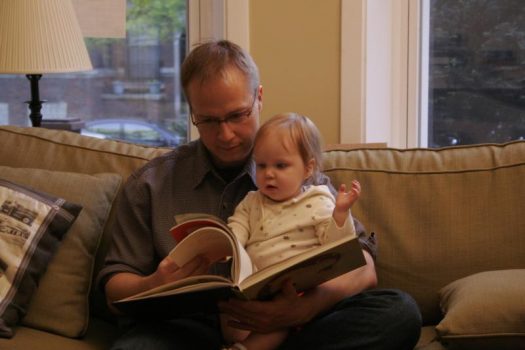 Dad reading book to child