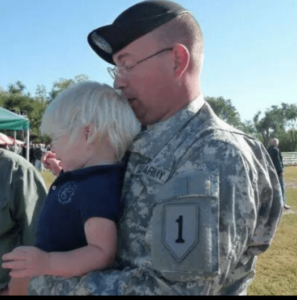 military member holding small child