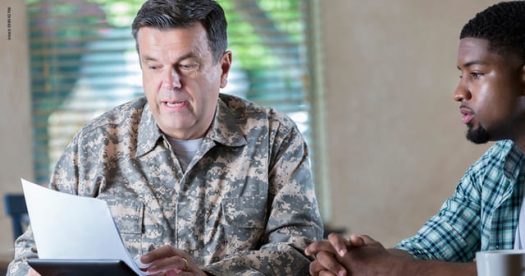 Service member going over documents with man