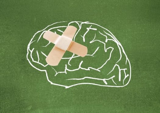 Illustration of a brain on a chalkboard with a bandaid
