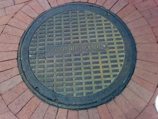 Manhole cover embossed with the word "communication"