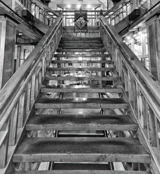 A black and white photo of a wooden staircase.