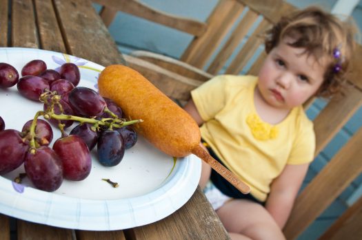Image of young girl looking disgustingly at the food on her plate