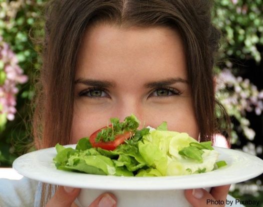 woman holding plate of salad