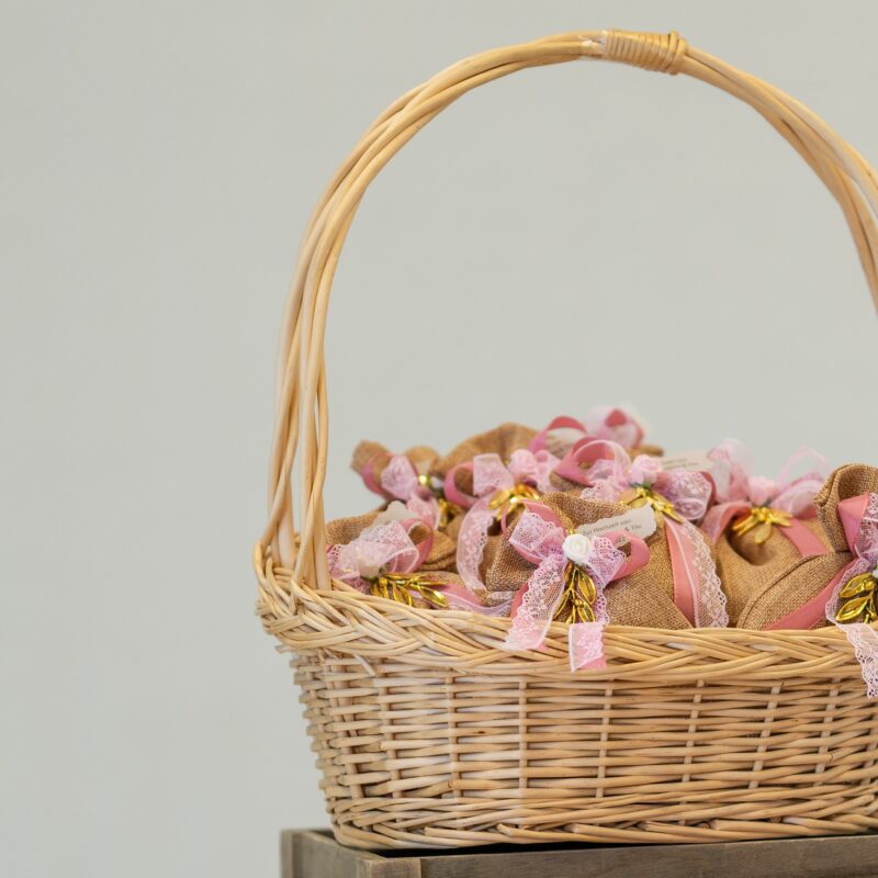Basket full of wrapped gifts with pink bows.