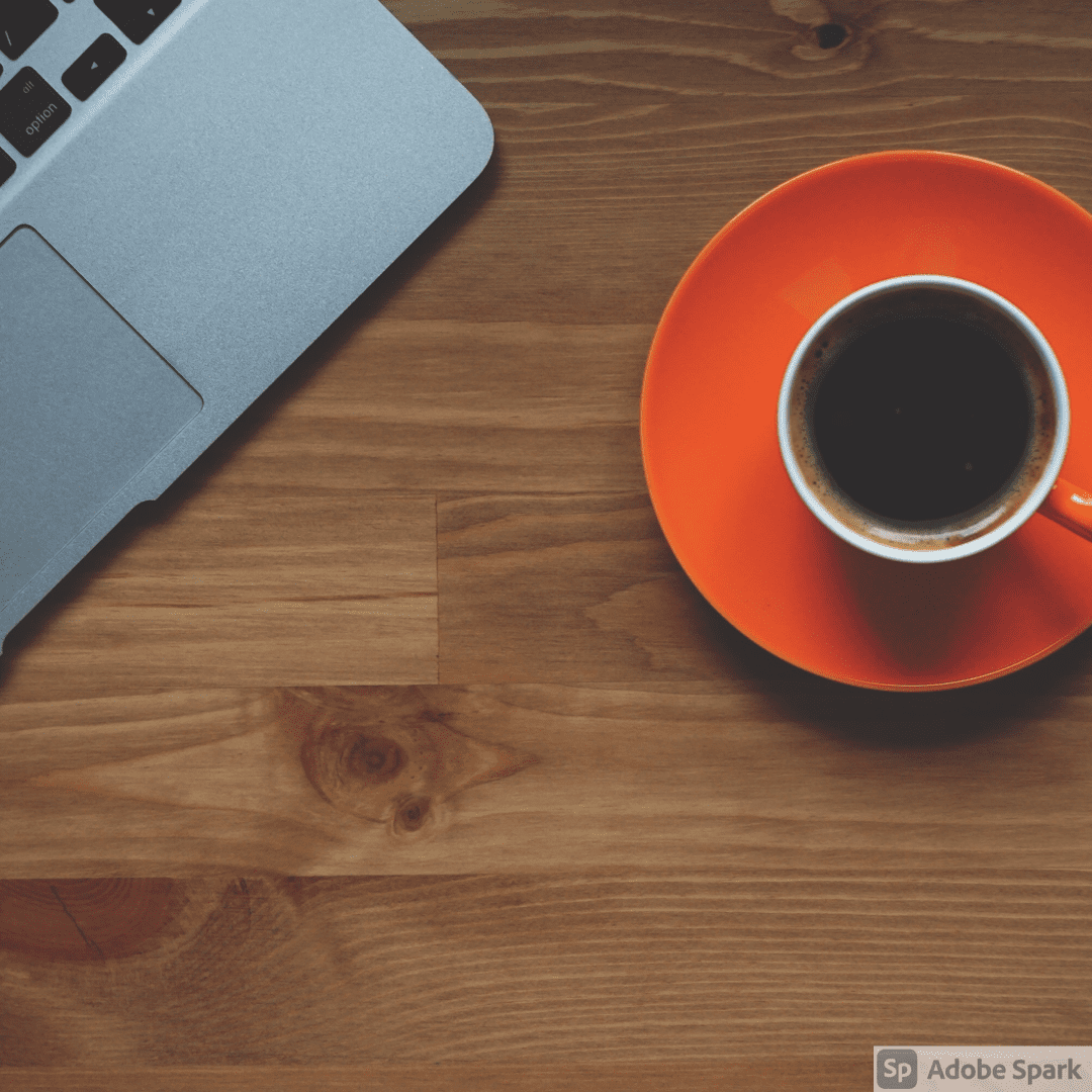 a computer and a cup of coffee on a wood surface
