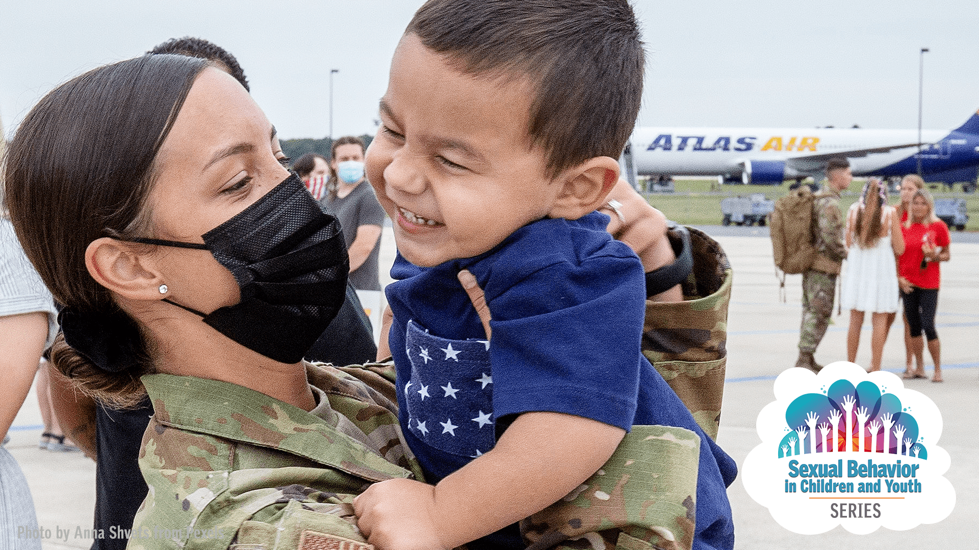 image of military mom hugging and holding up smiling young boy