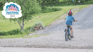 Image of young boy riding bike down gravel lane