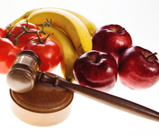 Apples and bananas near a judges hammer for food justice