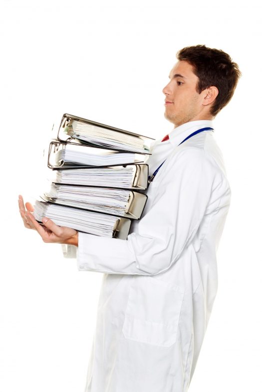 Doctor holding a large stack of thick binders