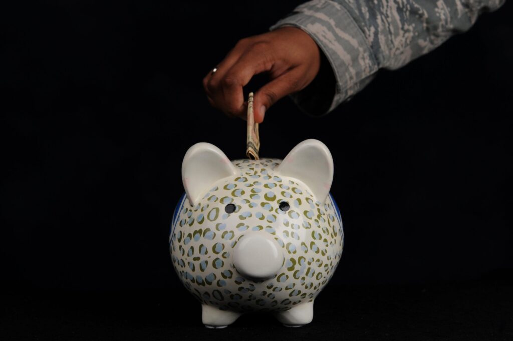 Hand placing money in piggy bank