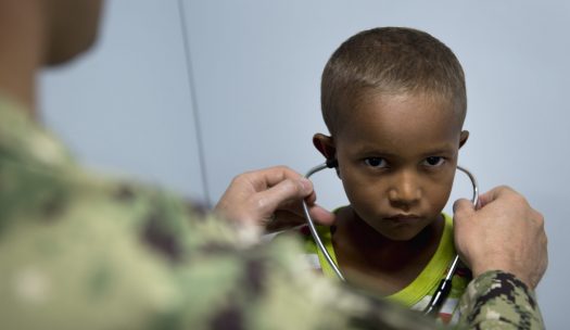 young boy with a serious face tries stethoscope