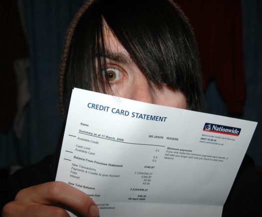 Shocked person holding a credit card statement
