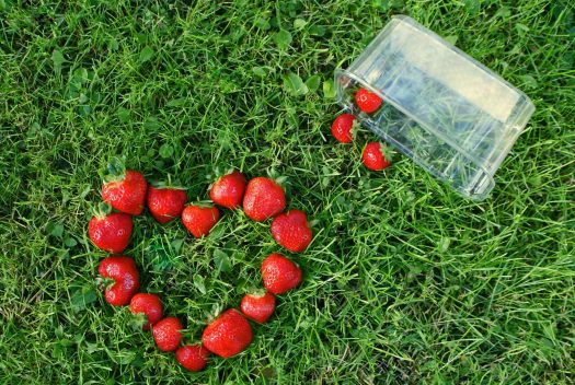 Strawberries in the grass arranged in the shape of a heart