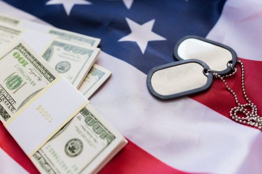 Money and military tags on top of American flag