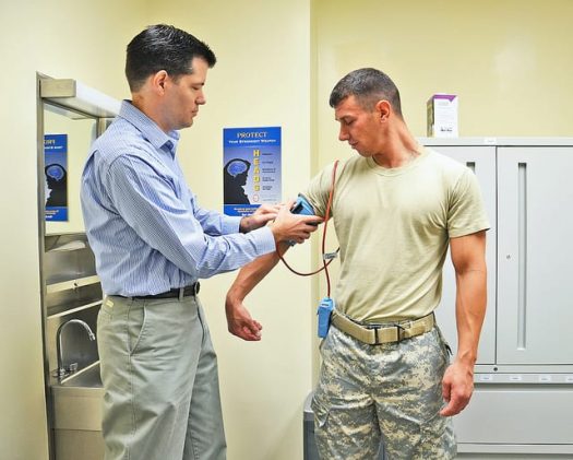 Pharmacist takes blood pressure of Service member