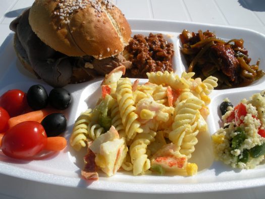 Lunch tray with food including sandwich, fruit, and pasta salad