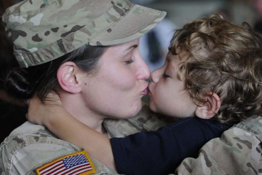 Little boy kissing his Service member mother