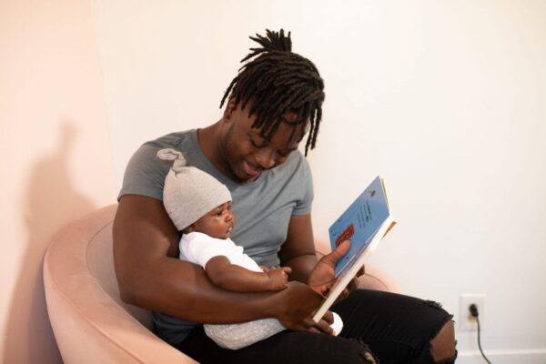 man reading storybook to baby