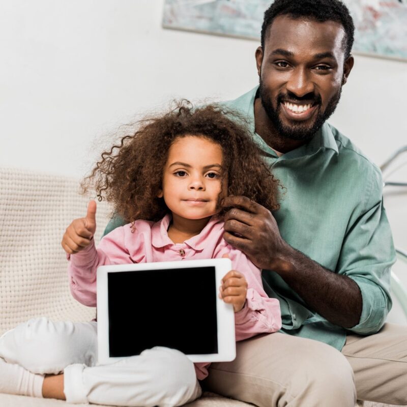 father and daughter sitting with tablet