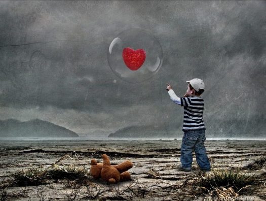Child reaching out to a heart in a bubble