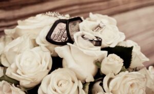 Bouquet of flowers with wedding rings and military tags