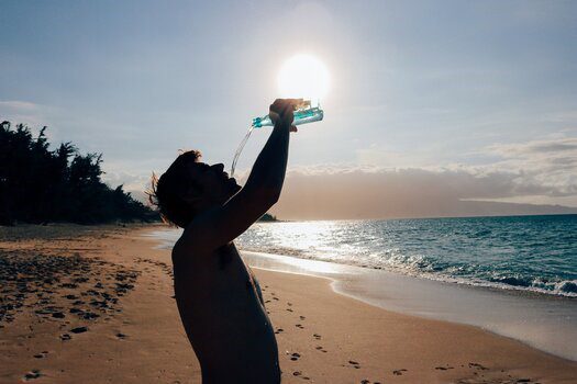 Man drinking water on the beach
