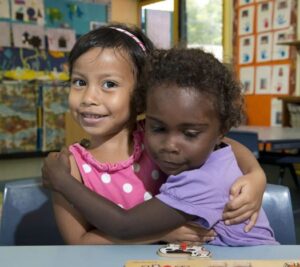 two young girls hugging as friends