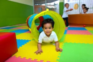 young boy crawling through play tunnel