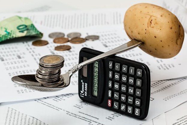 calulater balancing a potato and coins