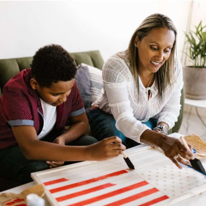 Mother and son painting an American Flag wood cutout a