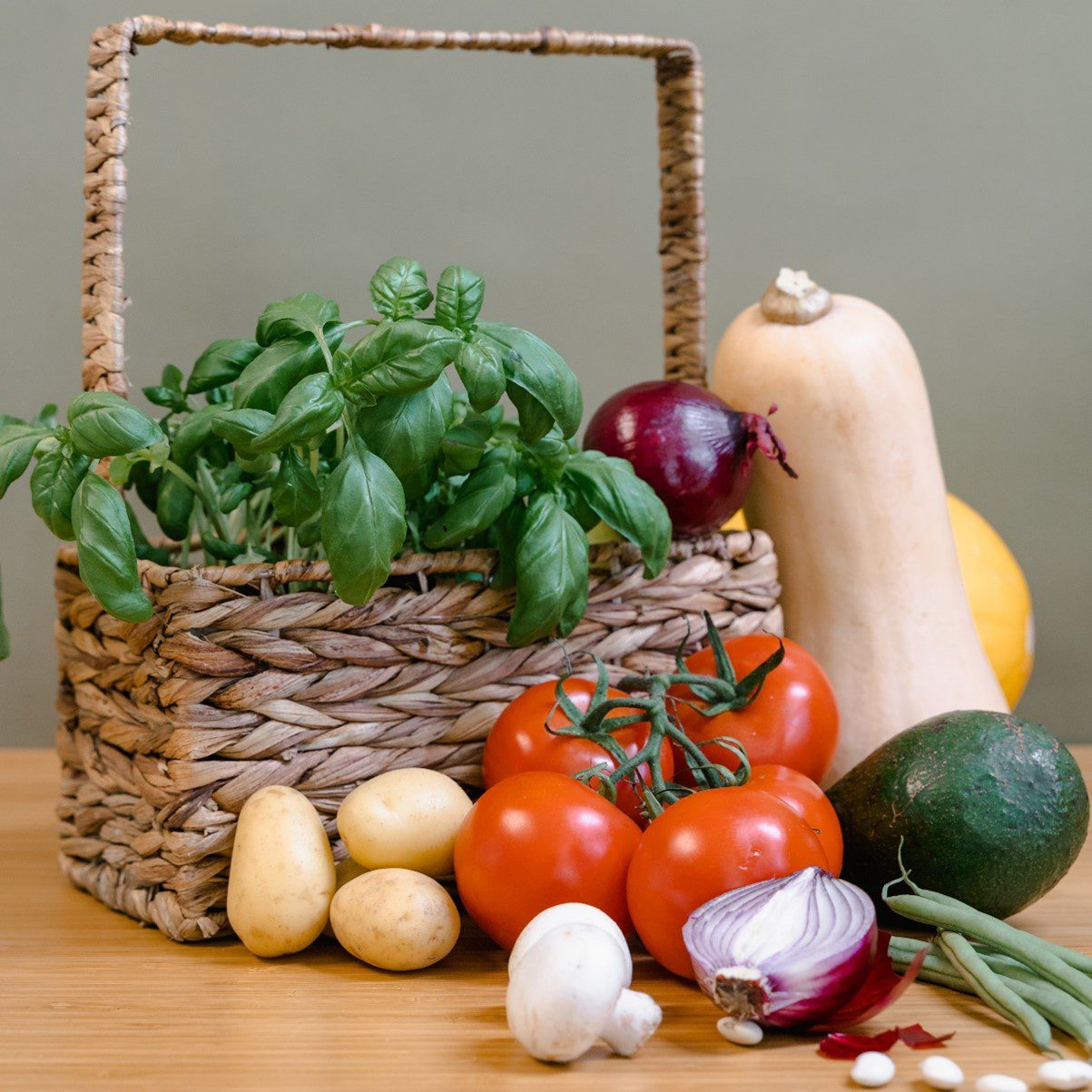 Basket of herbs and local vegetable surrounding the basket