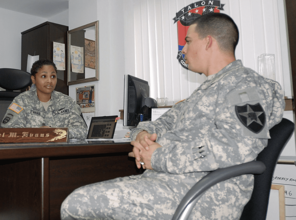 Military personnel speaking over a desk