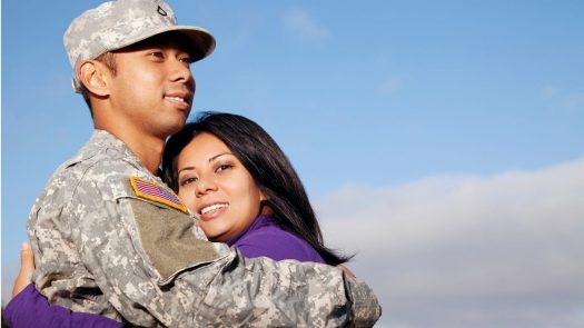 Soldier in uniform embracing a loved one in a hug