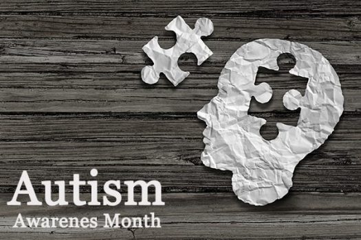 Autism Awareness Month banner showing paper cutout of a head missing a puzzle piece