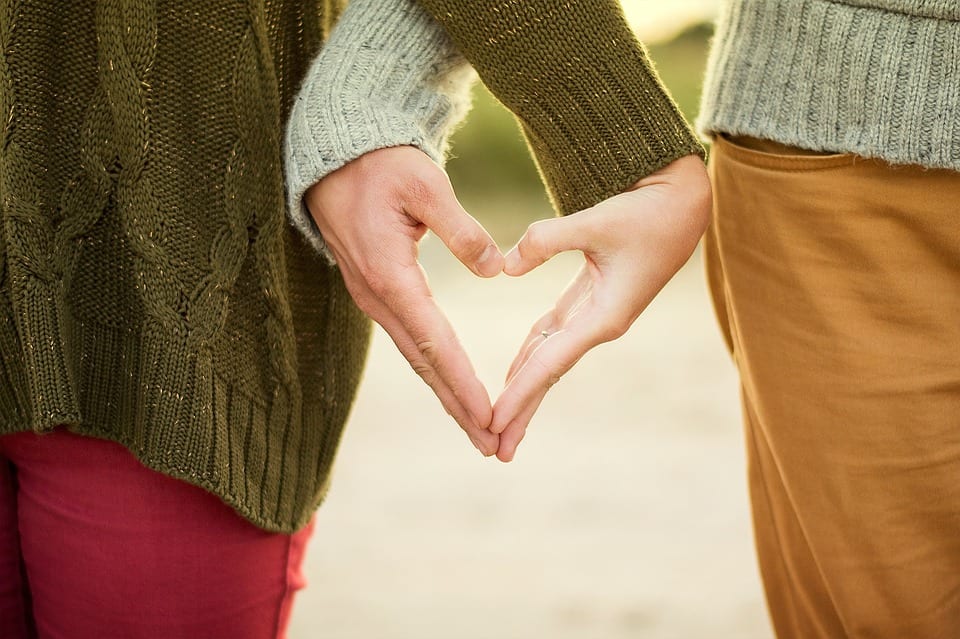 Couple making a heart out of their hands