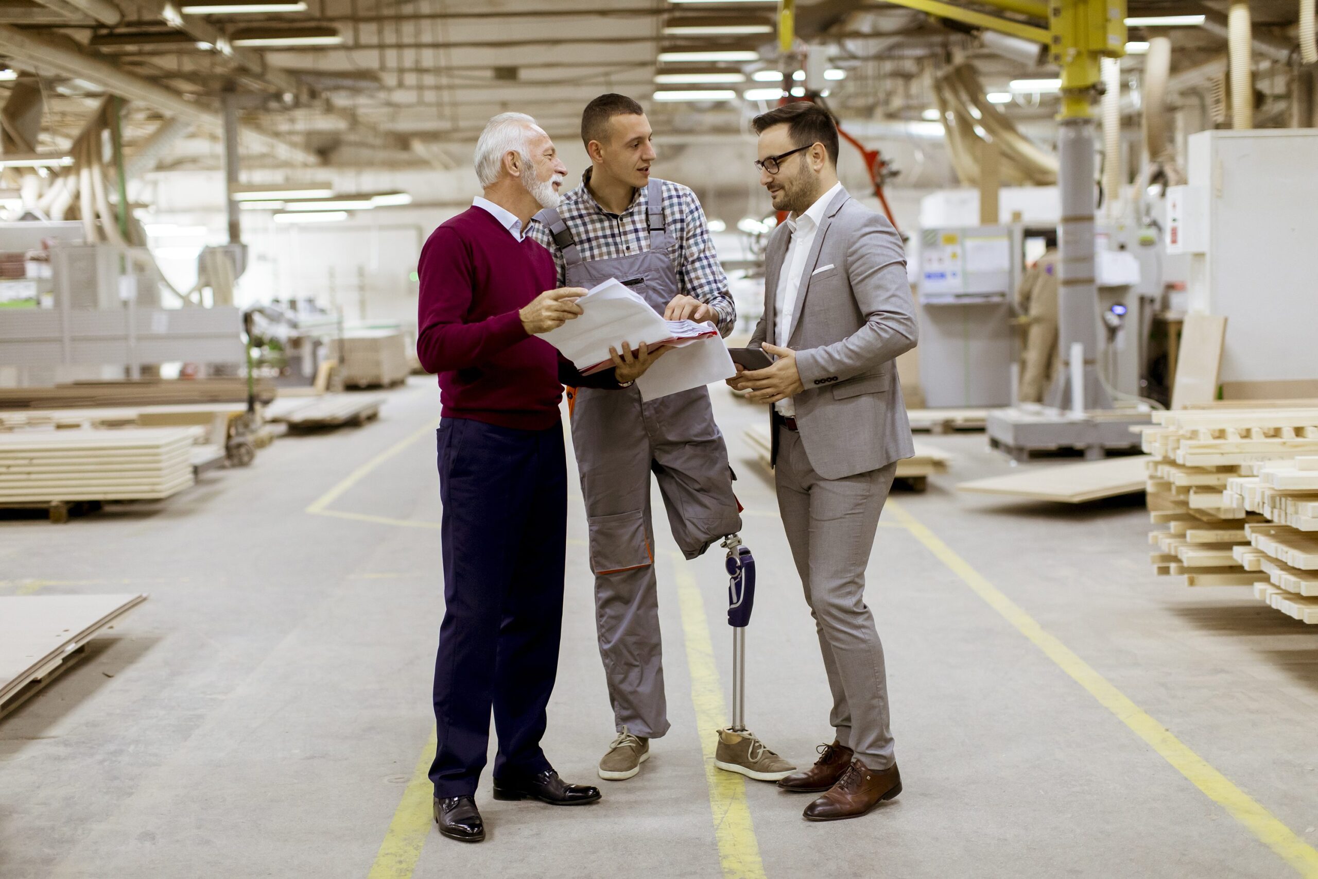 Three men standing and discuss in furniture factory