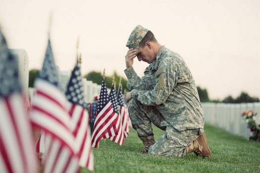 soldier kneeling at grave