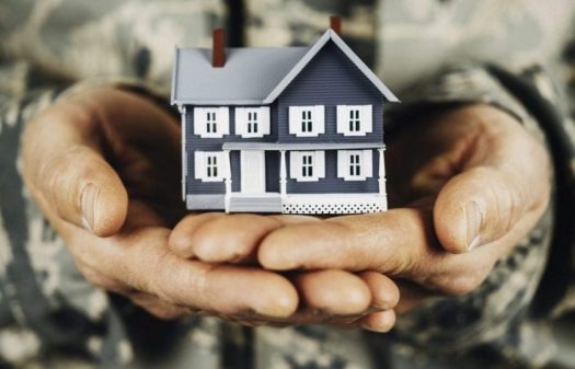 Close up of military service member holding a miniature house