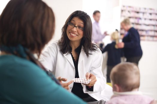 Doctor cheerfully counseling mother with child