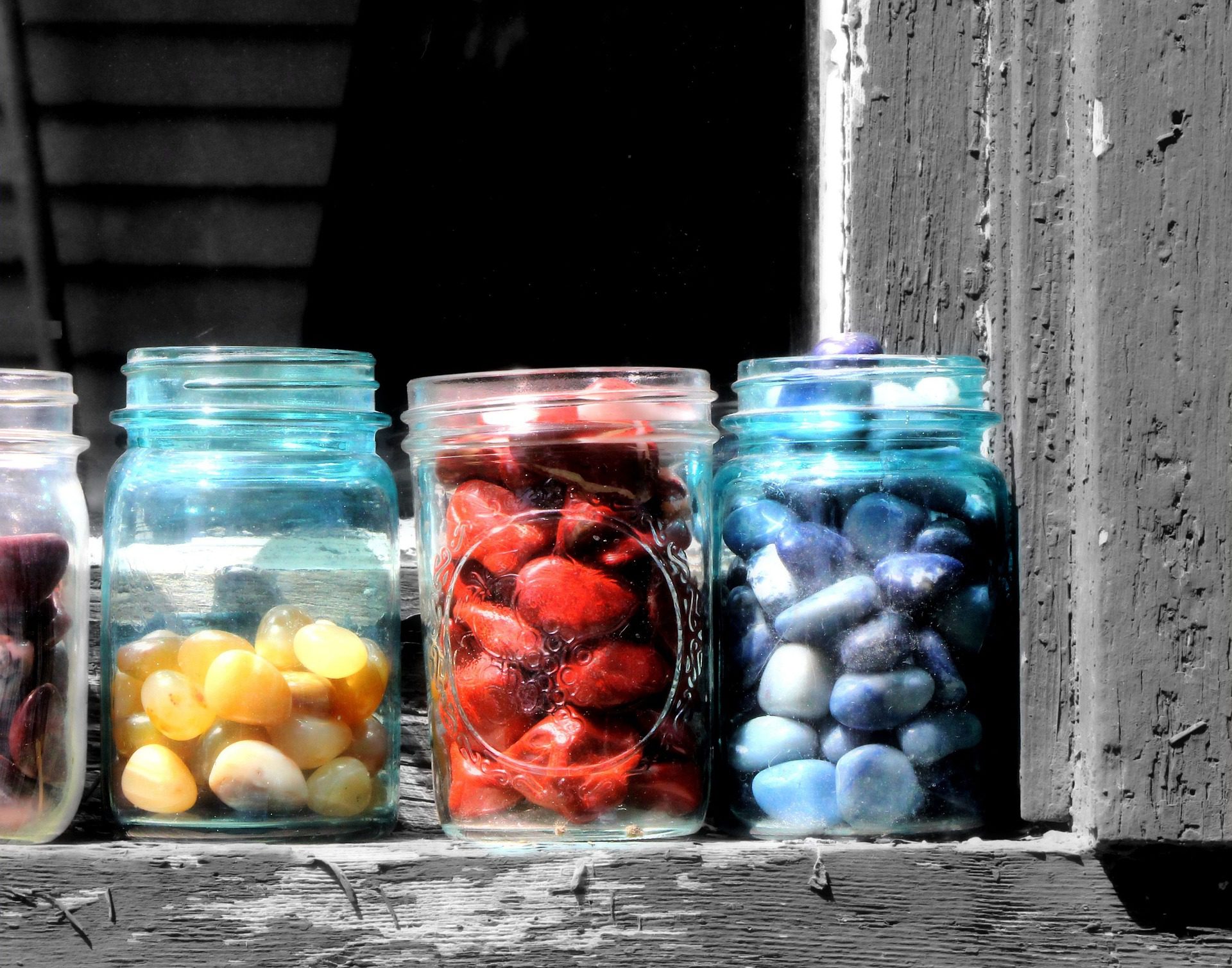 Clear jars of yello, red and blue rocks