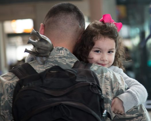 Military father holding young daughter