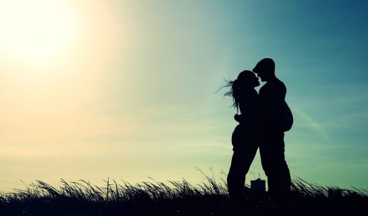 Silhouette of military couple embracing outdoors