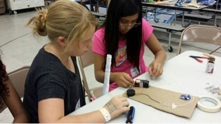 Military youth connect the wires to the battery pack to make their own “Operation” Game
