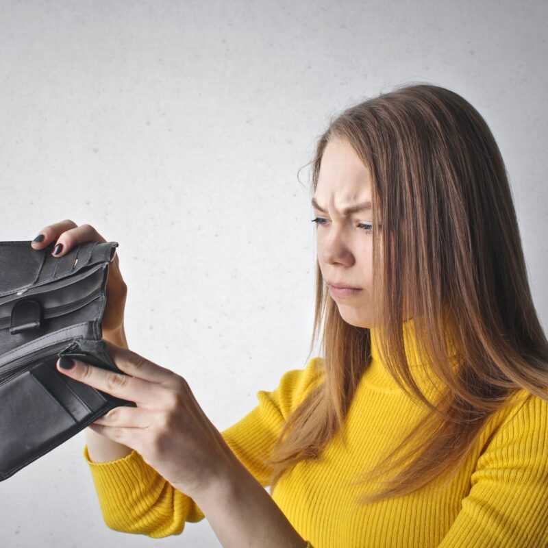 woman looking at empty wallet